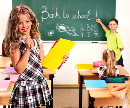group people schoolchild in classroom at school girl with pens