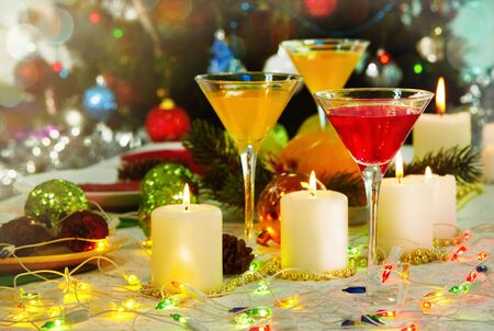 image of holiday table with cocktails burning candles and