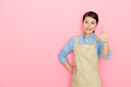 陽気なかわいい女性の家政婦が衣類のバスケットを持ち ピンクの背景に孤立した自分自身を励ますために叫んで手を上げました の写真素材 画像素材 Image