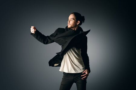 ファッションは 黒のスーツが灰色の背景で動きのポーズでハンサムな男性モデルのショット の写真素材 画像素材 Image ファッションは 黒のスーツが灰色の背景で動きのポーズでハンサムな男性モデルのショット の写真素材 画像素材 Image