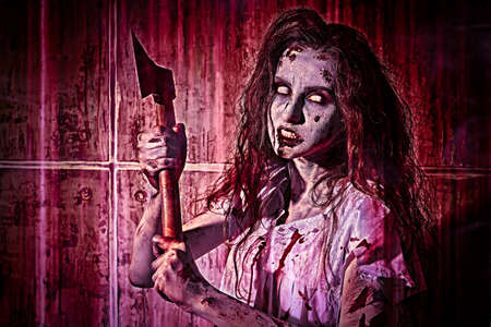 Creepy zombie woman with white eyes and shaggy hair stands in a bloody nightie with a bloody ax in her hands in red light and against a blood-covered wall. obsessed woman. horror, thriller. halloween. Фото со стока Creepy zombie woman with white eyes and shaggy hair stands in a bloody nightie with a bloody ax in her hands in red light and against a blood-covered wall. obsessed woman. horror, thriller. halloween. Фото со стока