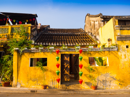 Green and red lanterns hanging outside of an old yellow house in Hoi An ancient town, UNESCO world heritage. Hoi An is one of the most popular destinations in Vietnam