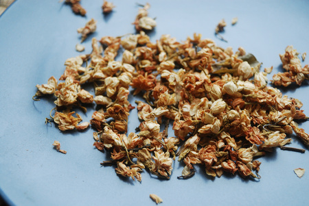 Dried jasmine buds on a plate.