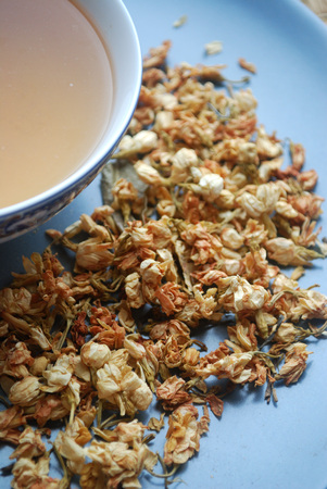 Bowl of jasmine tea with dried flower buds.