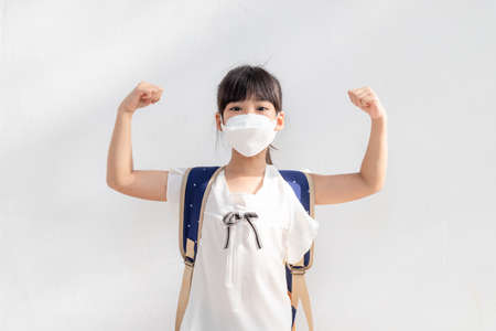 Student wearing surgical face mask and backpack