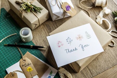 thank you card with wrapped craft paper gift box background stock