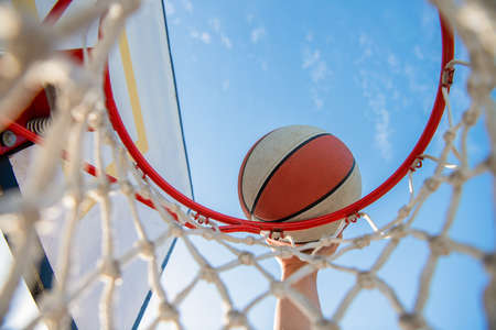 Man throwing the ball in hoop hands and basketball dunk in basket slam dunk in motion