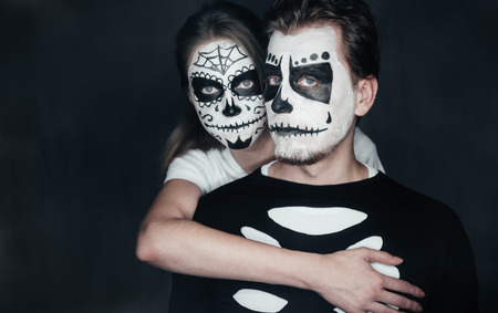 couple in love with dark skull makeup on black halloween face art stock photo