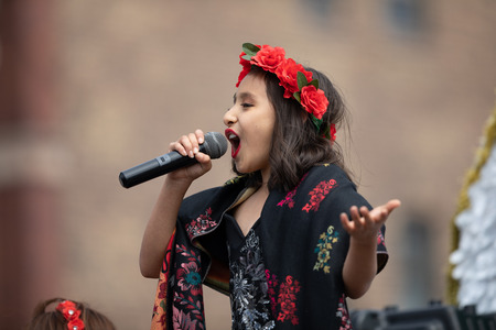Chicago, illinois , usa - september 9, 2018 the 26th street mexican independence parade, mexican girl wearing traditional clothing on top of a float singing el cielito lindo during the parade Stock Photo