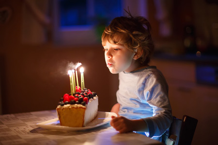 かわいい 5 歳の子供男の子彼の誕生日を祝うと自家製焼き菓子 屋内にろうそくを吹いています 子供のための誕生日パーティー の写真素材 画像素材 Image