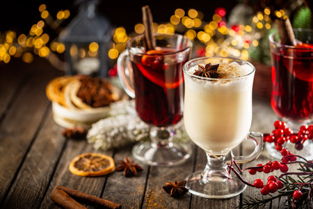 Fresh Yellow Eggnog And Fruity Red Mulled Wine With Christmas Decoration. Selection Of Autumn Or Winter Alcoholic Hot Drinks