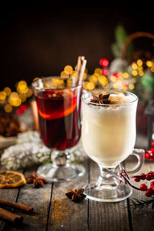 Fresh Yellow Eggnog And Fruity Red Mulled Wine With Christmas Decoration. Selection Of Autumn Or Winter Alcoholic Hot Drinks