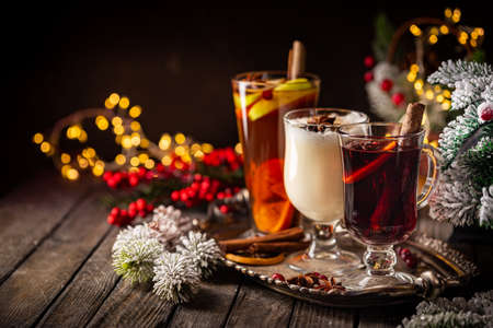 Fresh Yellow Eggnog, Grog And Fruity Red Mulled Wine With Christmas Decoration. Selection Of Autumn Or Winter Alcoholic Hot Drinks