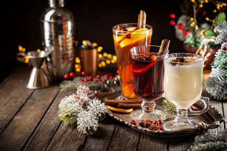 Fresh Yellow Eggnog, Grog And Fruity Red Mulled Wine With Christmas Decoration. Selection Of Autumn Or Winter Alcoholic Hot Drinks