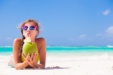 coconut: phụ nữ trẻ mỉm cười nằm trong chiếc mũ rơm trong kính mát với dừa trên bãi biển Kho ảnh