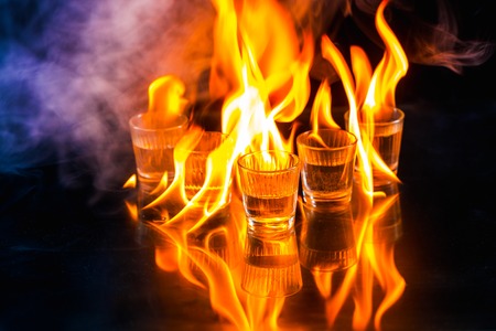 Glasses with burning alcohol on  black background