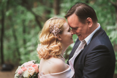 bride and groom kissing in the summer forest.