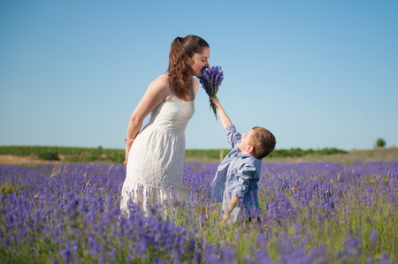 Happy little son gives mother to smell the flavor of a bouquet of flowers
