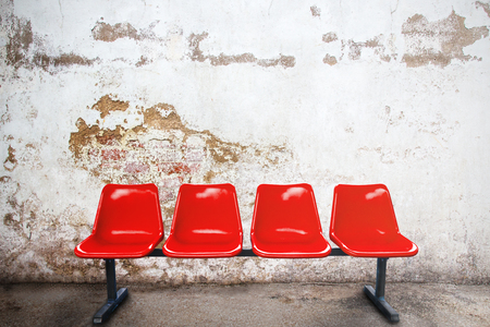 red chair in empty room against a vintage buildings exterior stock