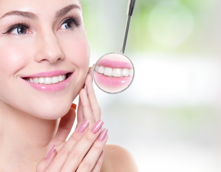 Atractiva mujer sonriente cara con los dientes de salud close up y un espejo de boca de dentista, el concepto de atención dental Foto de archivo - 25112546