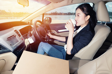 若い女の子が彼女の車をドライブに行く前にコーヒーを飲みます の写真素材 画像素材 Image