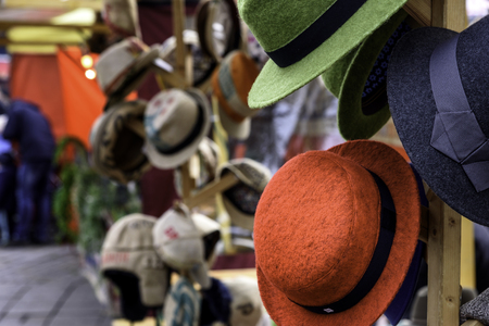 Group of colored hats for sale hanging on a wall market