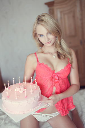 Anniversaire du jour - Page 29 44398920-femme-blonde-avec-un-g%C3%A2teau-d-anniversaire-%C3%A0-genoux-sur-le-lit