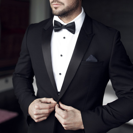 Sexy man in tuxedo and bow tie posing