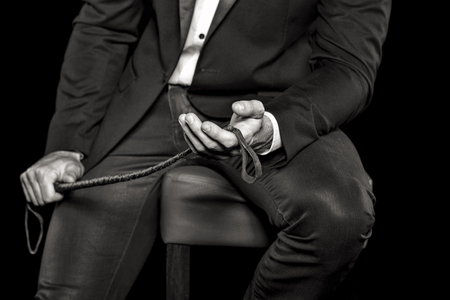79592836-rico-hombre-sentado-en-el-taburete-de-bar-y-la-celebraci%C3%B3n-de-l%C3%A1tigo-blanco-y-negro-bdsm.jpg?ver=6