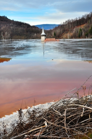 私はロジア モンタナ ルーマニア銅による汚染有害赤い湖の水で浸水教会 の写真素材 画像素材 Image
