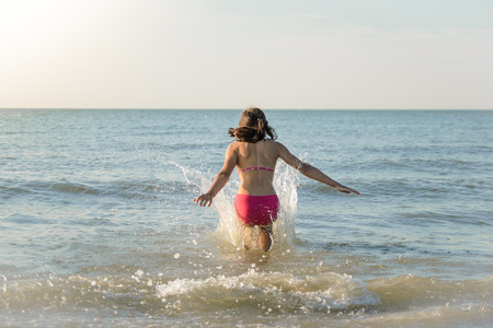 小さなかわいい女の子 海に実行している水にジャンプします 北の海で日当たりの良い海岸です の写真素材 画像素材 Image