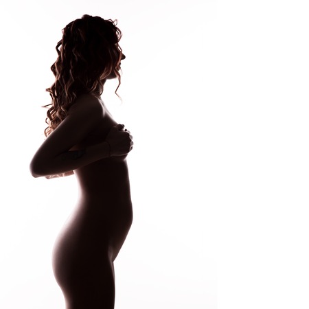 silhouette of beautiful woman on a early gestation, pregnant belly. free space for your text