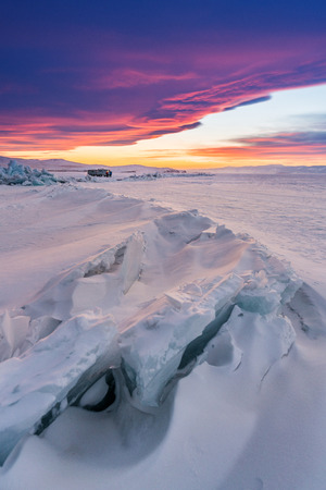 日没の冬の風景 美しい夕日の空とロシアのバイカル湖で雪に覆われた凍った湖 の写真素材 画像素材 Image