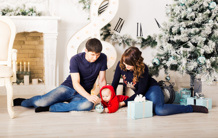 クリスマスの家族の肖像画のホーム休日リビング ルーム 子供たちと犬プレイ プレゼント ギフト ボックス 家を飾るクリスマス ツリーのキャンドル 株 ガーランド の写真素材 画像素材 Image