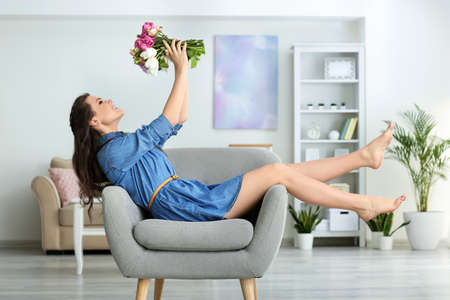 Beautiful Young Woman With Bouquet Of Flowers At Home