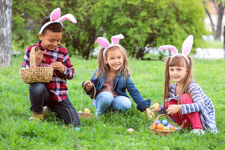 Petits enfants rassemblant des oeufs de pâques en parc