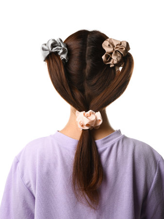 Woman with stylish hairdo and different scrunchies on white background