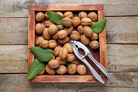 나무 배경에 신선한 호두와 호두까기 인형이 있는 상자 스톡 콘텐츠