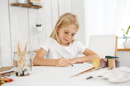 indoor portrait of cute little blonde haired girl with freckles