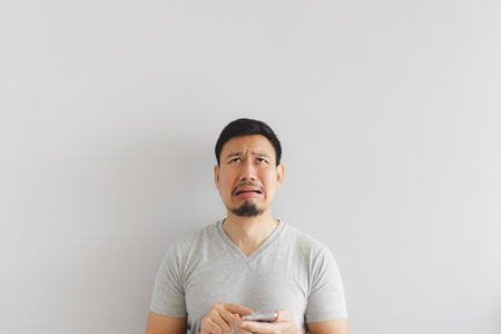 Asian man cry and sad with what show on the smartphone.