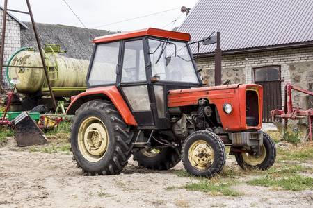 Old tractor for works in a fields ,where cultivated corn and grass for the cows .general view of the agricultural machine.equipment for a dairy farm.