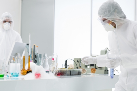 side view of people working in a laboratory with lab tools and colorful liquids on