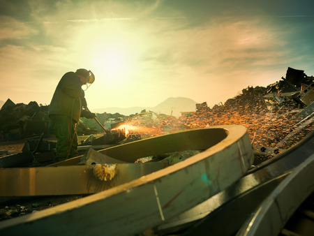 male worker wearing protective equipment welding metal outdoors. copy space available