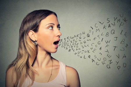 Woman talking with alphabet letters coming out of her mouth.