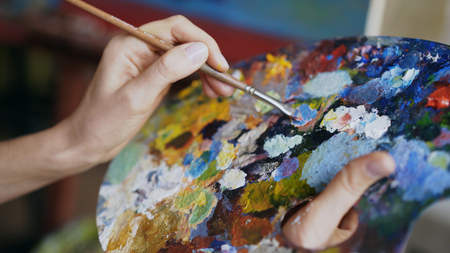 Close Up Of Womans Hand Mix Paints With Brush In Palette Art Class Close Up Of Womans Hand Mix Paints With Brush In Palette Art Class