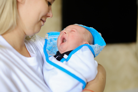 若い母親は 赤ちゃんに話す子 そっと手をつないで歌をなだめるような歌の世話します おむつの赤ちゃんは眉をひそめるし 泣く 母親の手を繋いで 光の部屋で手で中腰を横になっています 白 T に身を包んだ女性金髪欧州外観 の写真素材 画像素材 Image