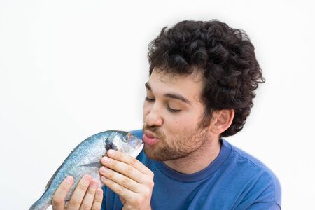 若い男は魚にキスします ひげで髪の毛 白い白人 白で隔離されます の写真素材 画像素材 Image