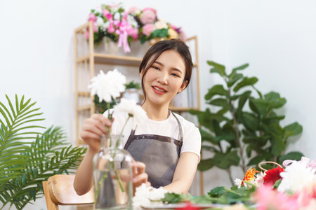 美しく魅力的なアジアの若い女性花屋または花屋の店員がバケツの