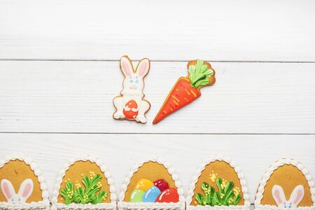 下部の白い木製の背景に卵形の異なるパターンでカラフルなイースター クッキー コピー スペースたっぷり の写真素材 画像素材 Image