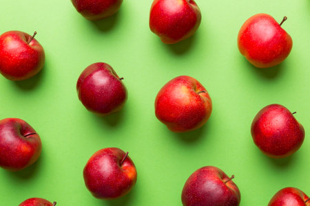 Many red apples on colored background top view autumn pattern with fresh apple above view